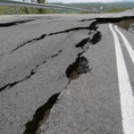Road damaged by significant cracks and fissures.