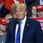 Trump PAUSES Military Strike — Last Second Intervention Person at a rally with Make America Great Again signs.