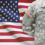 Army Colonel FIRED Over Major Crackdown Soldier in camouflage uniform standing before American flag.