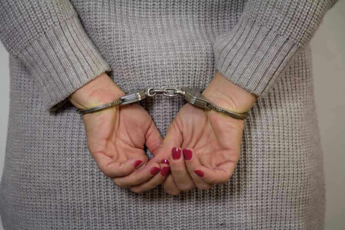 Person in handcuffs with gray sweater.