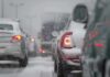 Cars stuck in traffic during a snowstorm with snow covering the vehicles