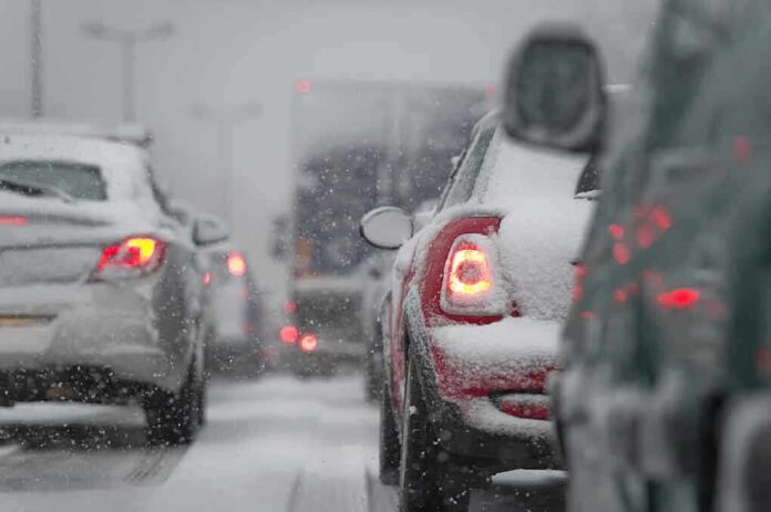 Cars stuck in traffic during a snowstorm with snow covering the vehicles