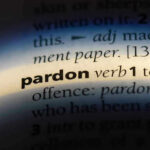 The word pardon highlighted in a dictionary.