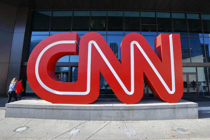 Large red CNN sign outside building entrance.