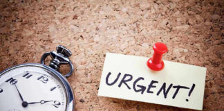 Pocket watch and urgent note pinned on corkboard