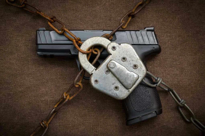 Pistol locked with chains and a padlock.