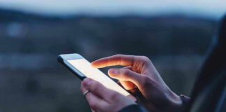 Person using a smartphone at dusk.