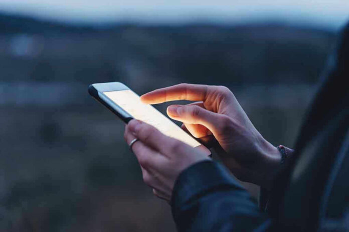 Person using a smartphone at dusk.