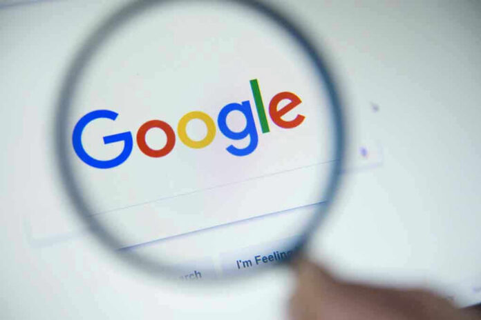 746561200 Google logo viewed through a magnifying glass.