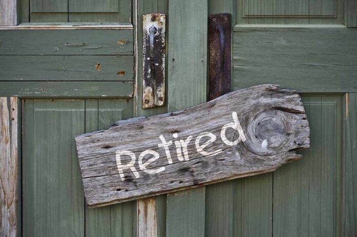 shutterstock_149656133.jpg Weathered wooden sign reading Retired hanging on a green door