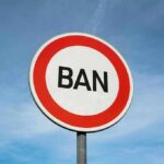 Paid Vote Harvesting BANNED — HUGE Conservative WIN! A road sign displaying the word 'BAN' against a blue sky