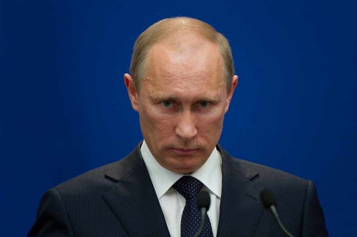 shutterstock_181590401.jpg A serious-looking man in a suit at a press conference with a blue background