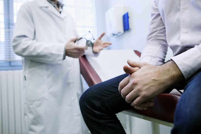 A doctor in a white coat discussing with a patient sitting on an examination table