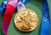 Gold Olympic medal from the Tokyo 2020 Games with a colorful ribbon