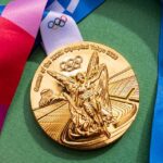 Gold Olympic medal from the Tokyo 2020 Games with a colorful ribbon