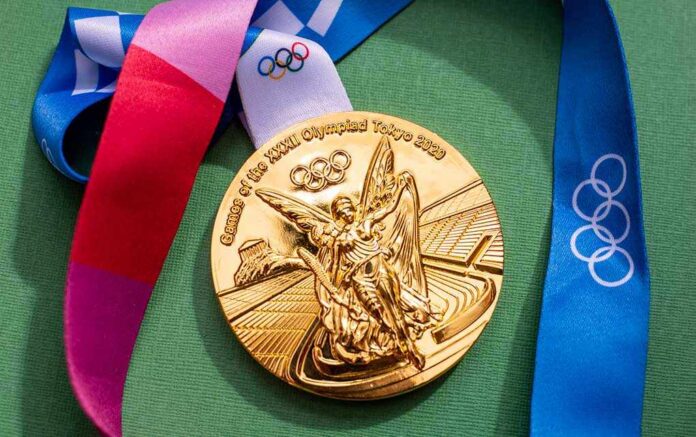 Gold Olympic medal from the Tokyo 2020 Games with a colorful ribbon