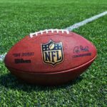 Trump’s Clemency Bombshell — NFL Royalty Freed An NFL football resting on a green grass field