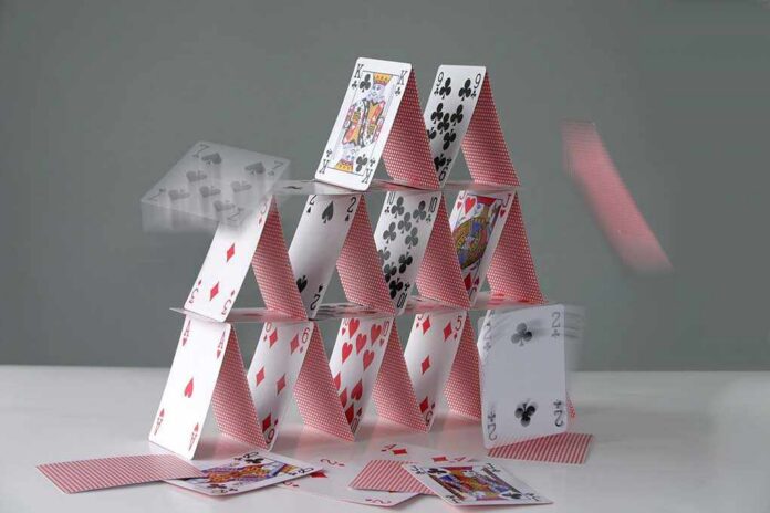 A house of cards collapsing with some cards in motion
