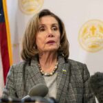 $130M Stock Haul Shadows Pelosi Farewell Nancy Pelosi speaking at a press conference with an American flag in the background