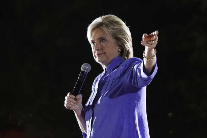 A woman speaking into a microphone while gesturing with her hand