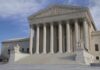 The Supreme Court building featuring large columns and statues