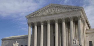 The Supreme Court building featuring large columns and statues