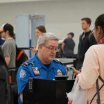 TSA Lines–Worse Than We THOUGHT TSA agent checks passengers documents at airport security.