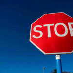 Rare Hamas Warning Stuns Iran Backers Red stop sign against a clear blue sky.