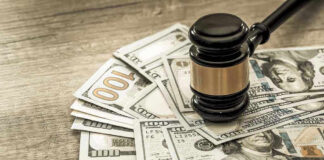 Gavel on a pile of hundred-dollar bills.