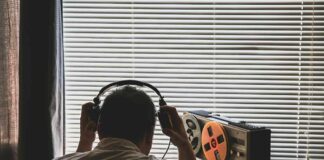 Person listening to music on headphones with a vintage tape recorder