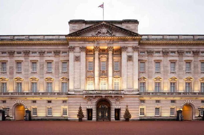 Front view of Buckingham Palace with illuminated facade and British flag