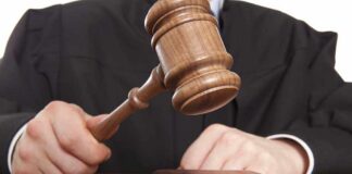 A judge holding a gavel above a wooden block