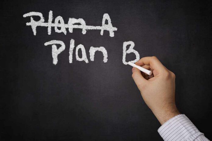 A hand writing Plan B on a chalkboard with Plan A crossed out