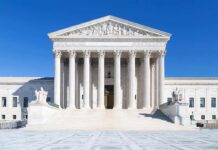 The Supreme Court building featuring marble columns and a clear blue sky