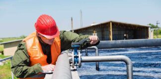 Worker in safety gear inspecting water treatment equipment