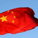 Axis of Chaos CRUMBLES—China Stunned Chinese flag waving against a clear blue sky