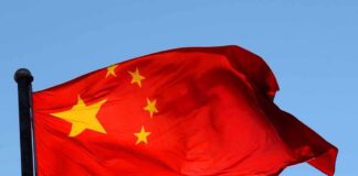 Chinese flag waving against a clear blue sky