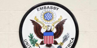 Seal of the United States Embassy featuring an eagle and the American flag