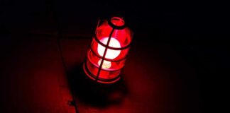 A red lantern emitting a warm glow in a dark setting