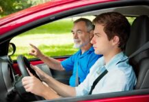 A young man driving a car with an older man giving instructions