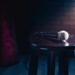 Microphone resting on a stool on stage.