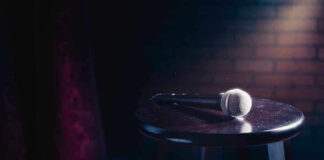 Microphone resting on a stool on stage.
