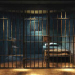 Empty prison cell with metal bars and bed.