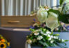 White roses in front of a casket.