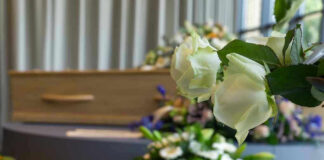 White roses in front of a casket.