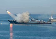 Warship firing missile in the sea.