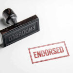 Rubber stamp with ENDORSED text on paper.