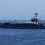 A large aircraft carrier sailing in the ocean