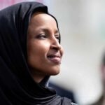 MASSIVE Wealth Vanishes—Omar’s $30M “EXPLANATION” A woman wearing a black hijab looking thoughtfully during an outdoor event