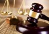 A wooden gavel and scales of justice on a table